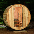 Wooden barrel-shaped sauna in a forest setting.