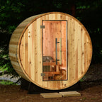Wooden barrel-shaped sauna in a forest setting.