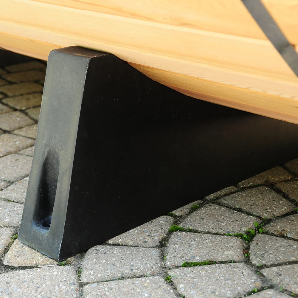 Wooden bench with a black metal leg on a paved surface.