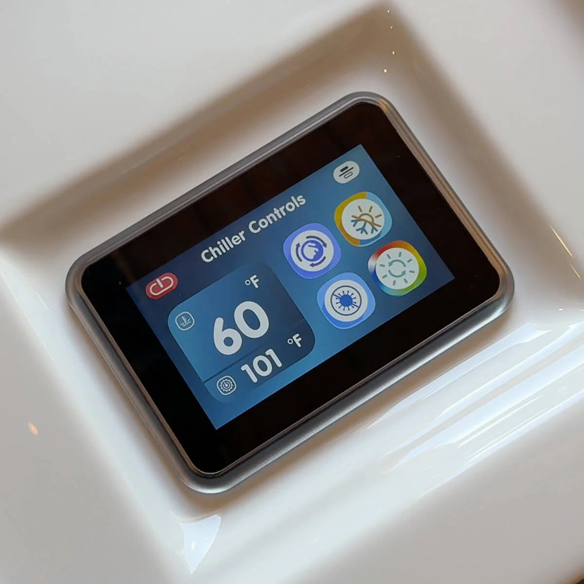 Digital display showing chiller controls with temperature readings on a white surface.
