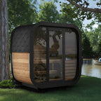 A 3-person luxury cube outdoor sauna near a lake.