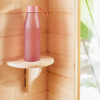 Pink water bottle on a wooden shelf with a blurred background.
